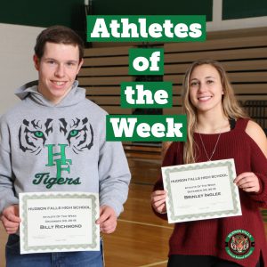 two students smile and hold awards