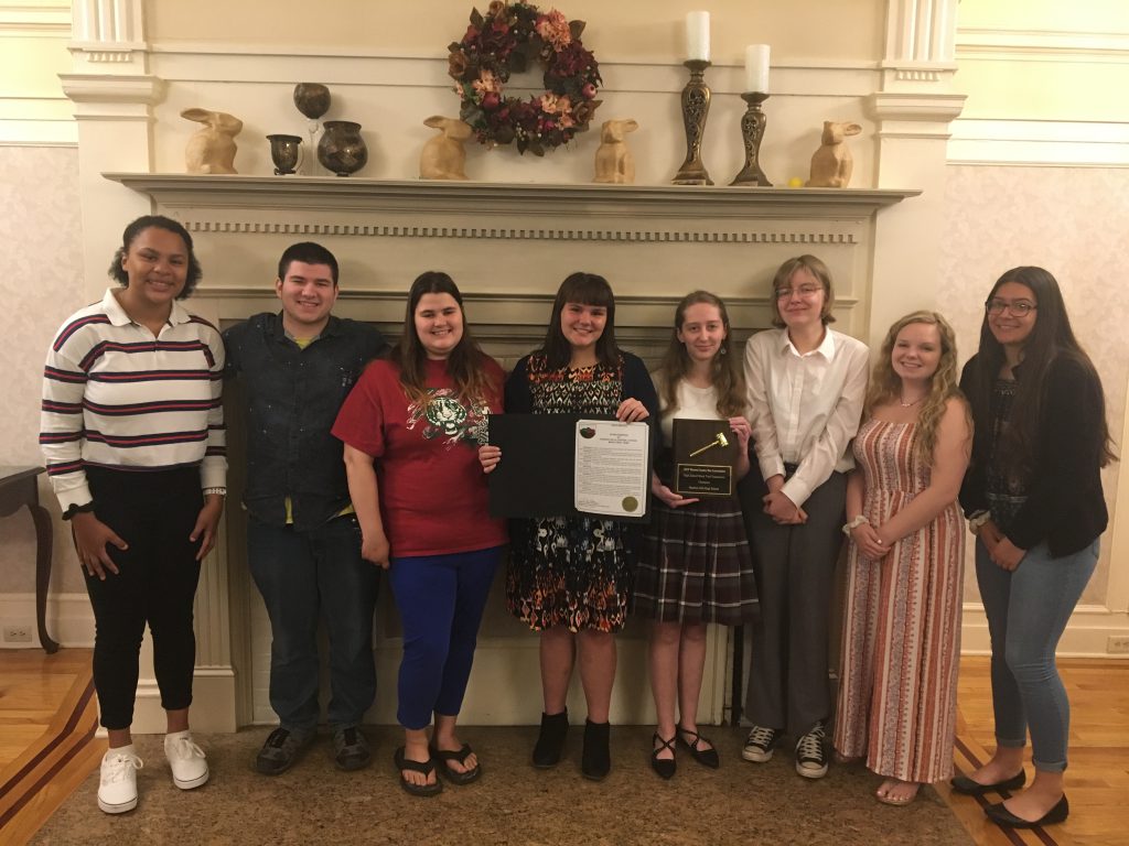 photo shows group of students smiling with an award