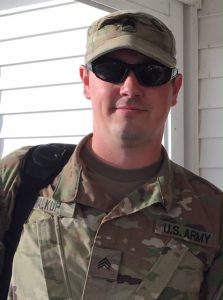 photo shows man in army uniform wearing sunglasses