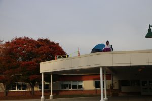 photo shows woman sitting on roof in camp chair