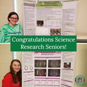 photo shows two women smiling and showing science projects