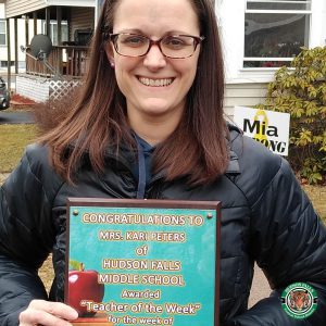 Photo shows woman holding award and smiling