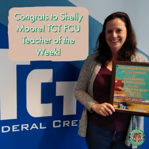 photo shows woman holding award and smiling