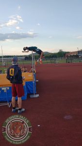 photo shows boy jumping over pole at track meet
