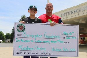 Photo of Giant check being presented to student by his teacher