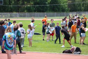 students out on the football field playing yard games and signing yearbooks