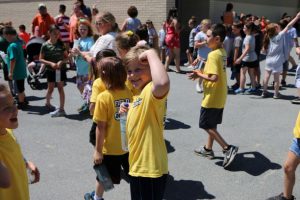 Student flexing his muscles around his classmates at field day