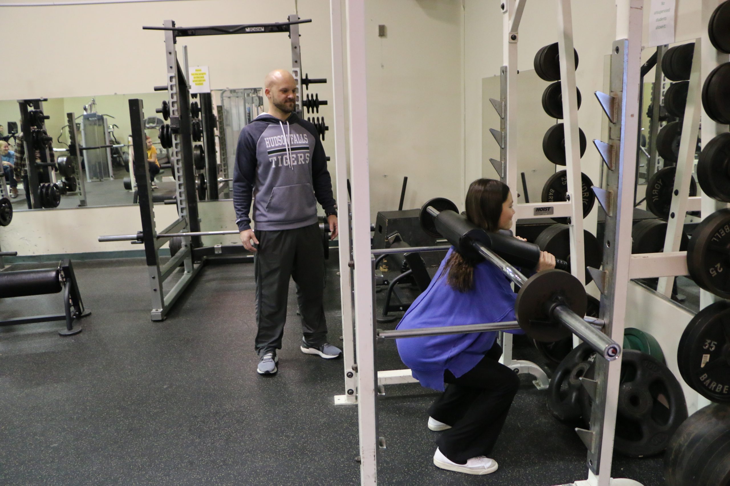 student doing back squats during PE class