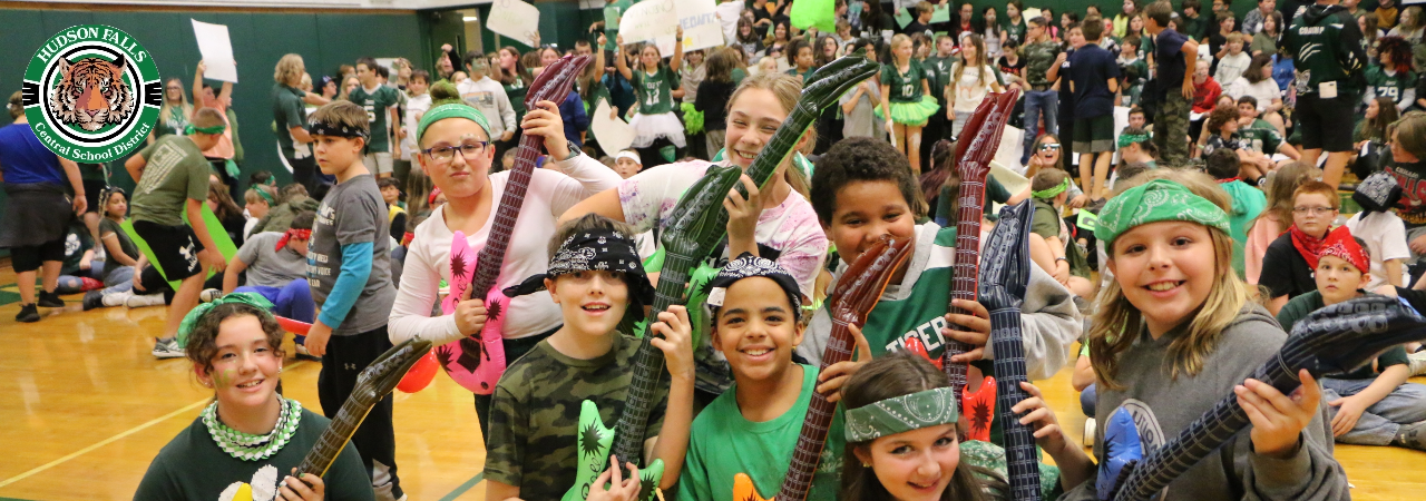A photo of students posing with inflatable guitars at the middle school pep rally