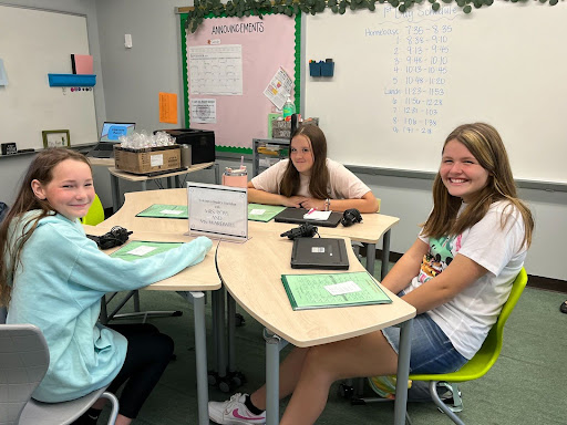 three female middle school students doing classwork at tables in the newly renovated classroom