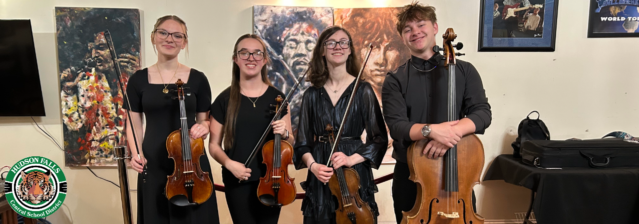 Photo of 4 students holding their string instruments