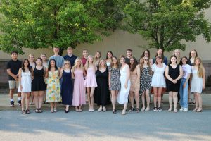 Group Photo of honors grads in front of the band room trees
