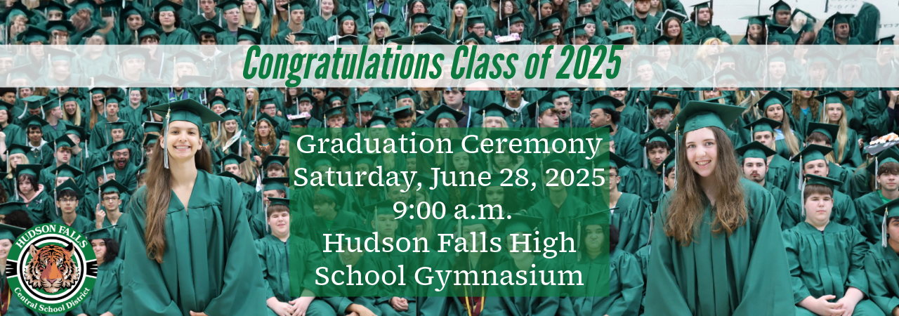 Photo of Salutatorian and Valedictorian in green cap and gown standing in front of their class in caps and gowns
